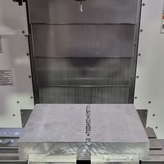 CNC machine setup with aluminium billet secured for milling